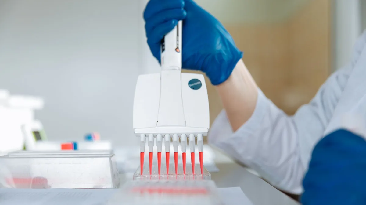 Close-up of a lab technician using a multichannel pipette for testing in a laboratory.
