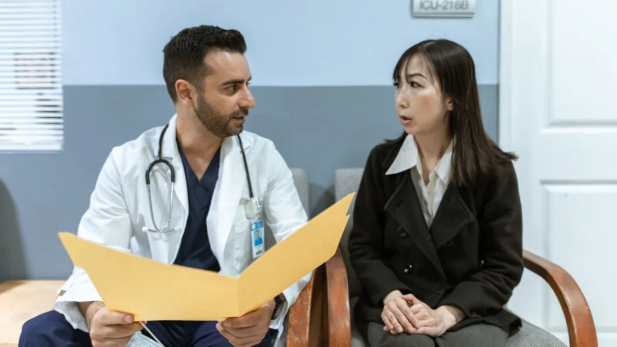 Healthcare professional consults patient in clinical setting.