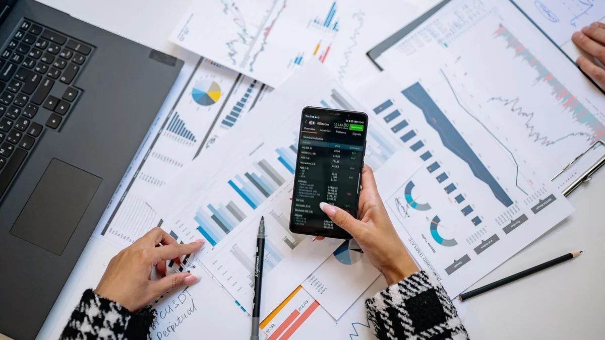 A top view on charts and smartphone in an office.