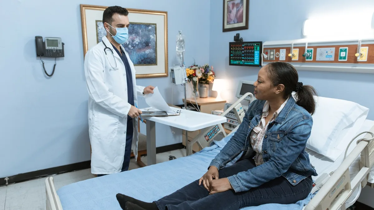 A medical professional conducts a check-up with a patient in a hospital setting.