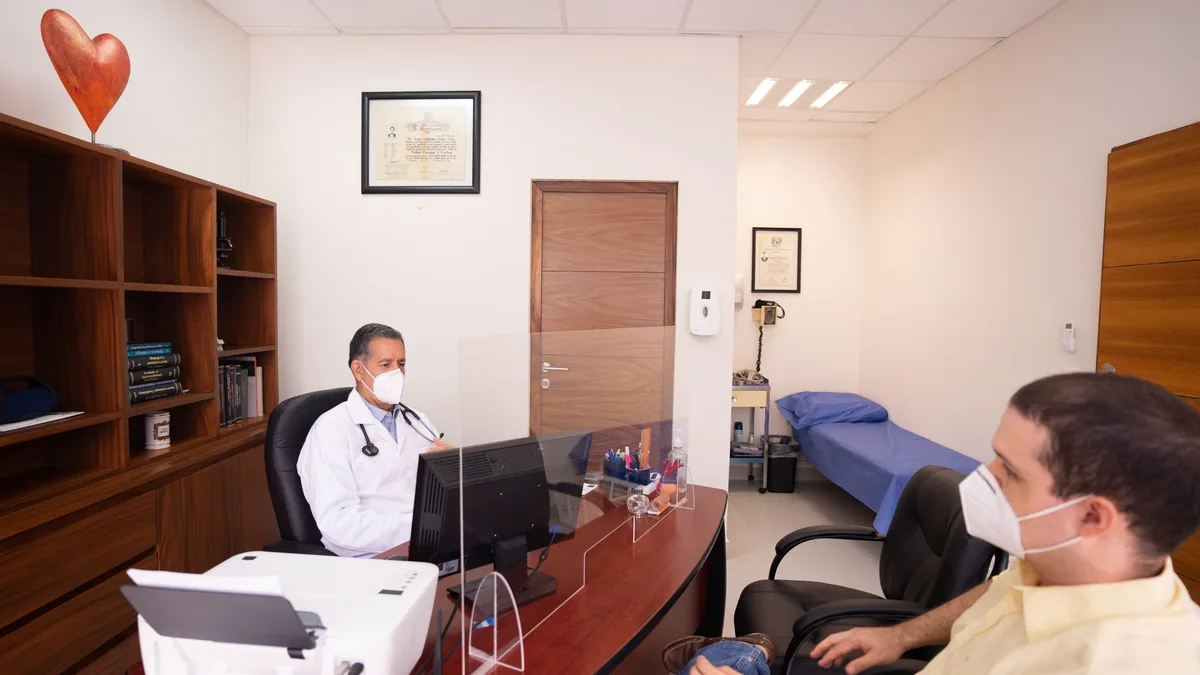 Doctor and patient with masks in medical clinic.