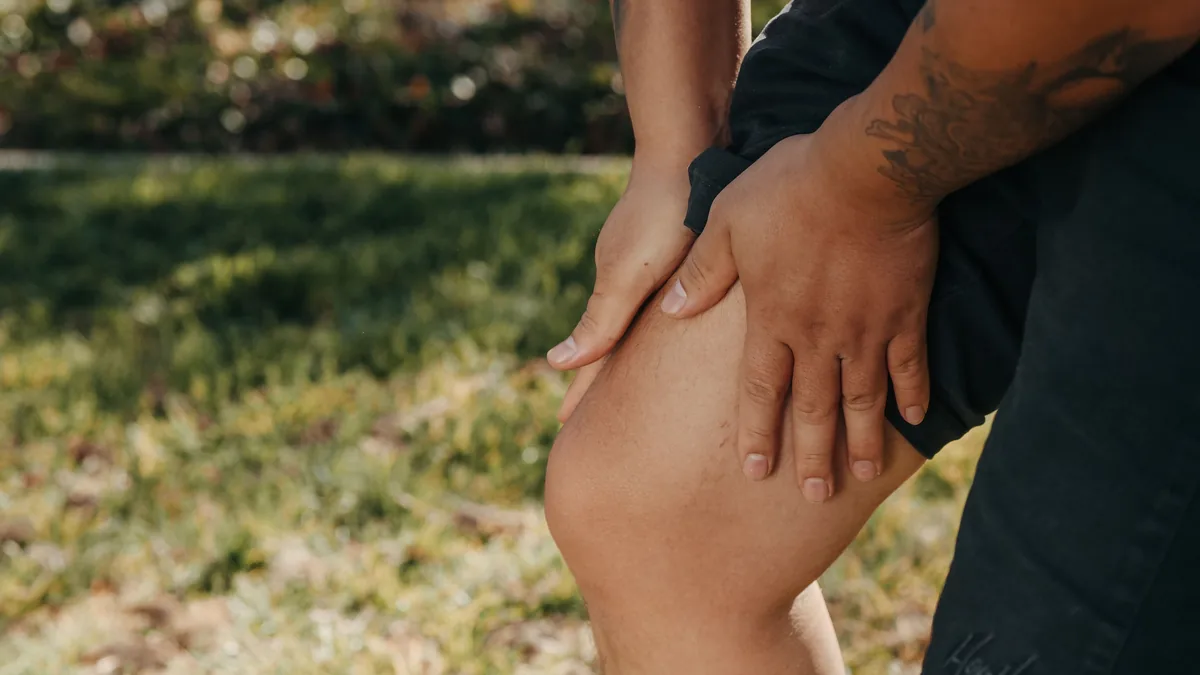 Person gripping a painful knee, a common sign of advanced knee osteoarthritis
