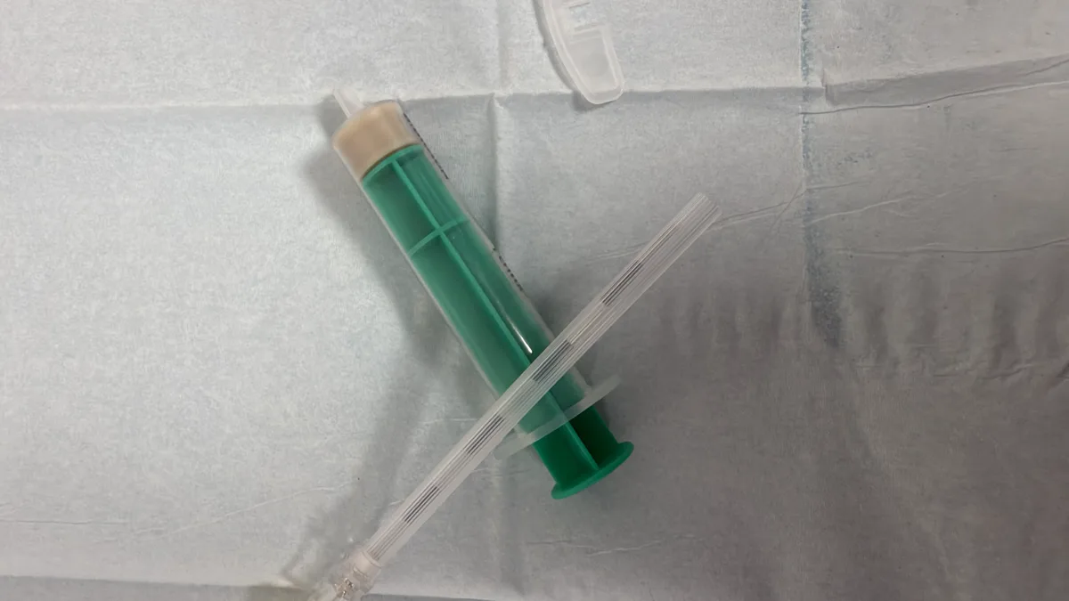 A loss-of-resistance syringe and epidural needle laid out on a sterile drape before an epidural injection.